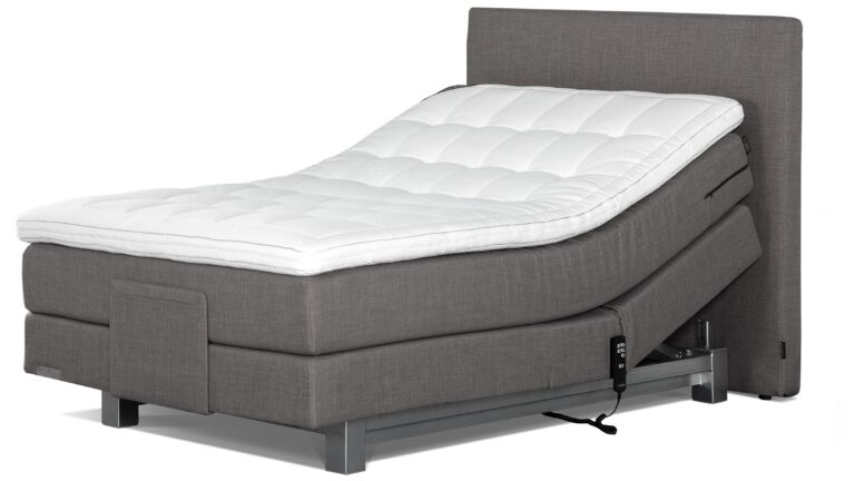 Boxspring Caresse 4600 Comfort met elektrische verstelling, gestoffeerd matras en topper, in een moderne slaapkamer.