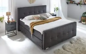 Boxspring Caresse 7060 tweepersoonsbed met gratis voetbord, grijze bekleding, formaat 180x200, comfortabele matrassen.
