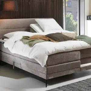 Elektrische tweepersoons Caresse 6800 boxspring met gestoffeerde hoofdbord en verstelbare bedbodem in een moderne slaapkamer.
