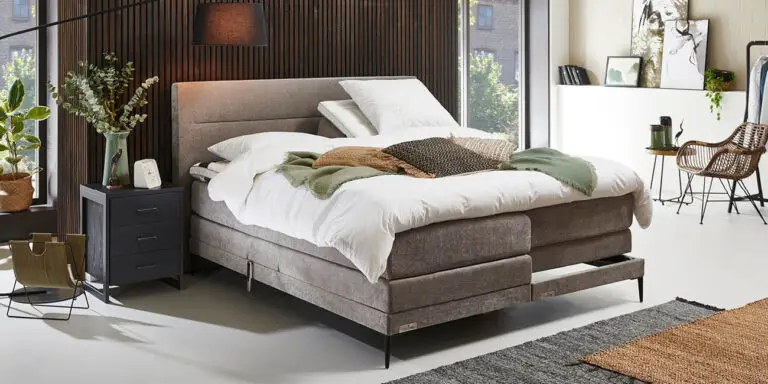 Elektrische tweepersoons Caresse 6800 boxspring met gestoffeerde hoofdbord en verstelbare bedbodem in een moderne slaapkamer.