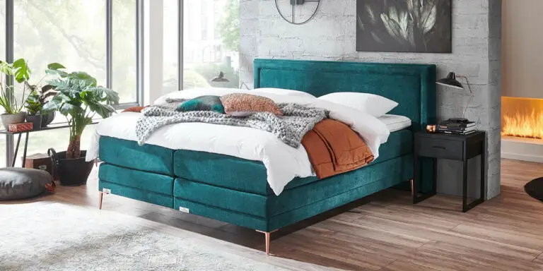 Boxspring Caresse 6950 in grijze stof, tweepersoons, met hoofdbord en matras, beschikbaar in diverse afmetingen.