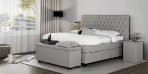 Boxspring Caresse 9850 tweepersoons in grijze stof met hoofdbord en matras, beschikbaar in diverse afmetingen.