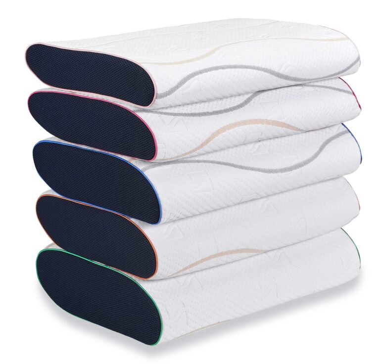 Wit M-Line Pillow You hoofdkussen met ergonomisch ontwerp op een bed met witte lakens.